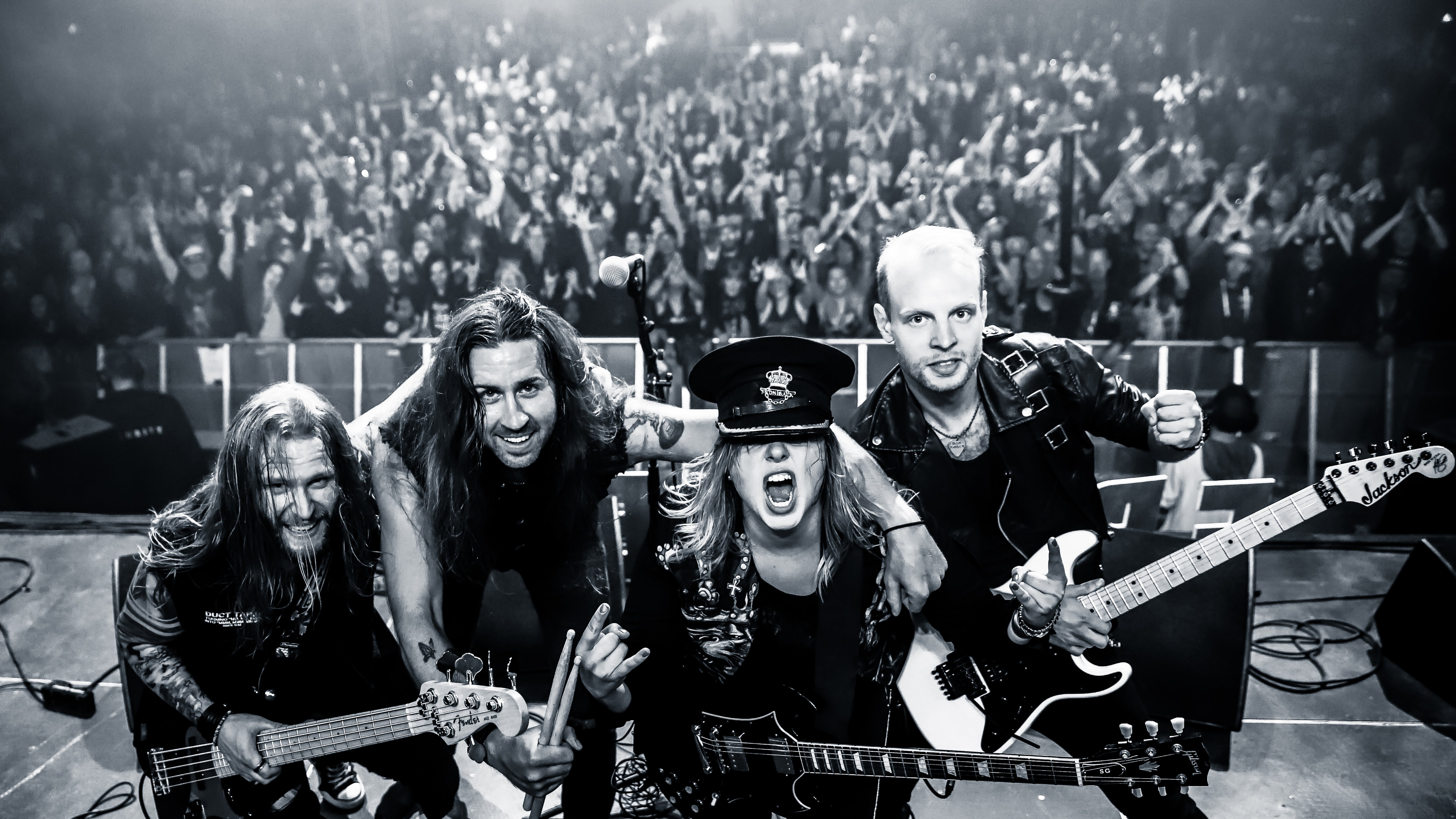 Bandet Frontback p&aring; scenen fotad mot publiken.